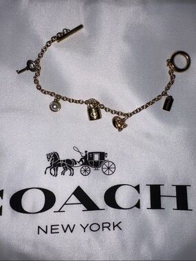 Coach Gold-Tone Charm Bracelet with Signature Lock and Tag